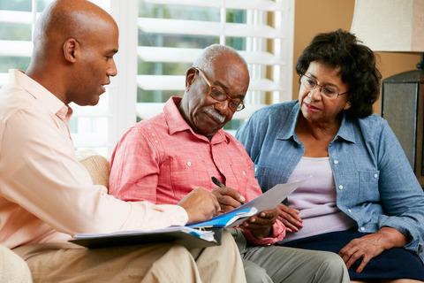 Professional discussing documents with senior couple.